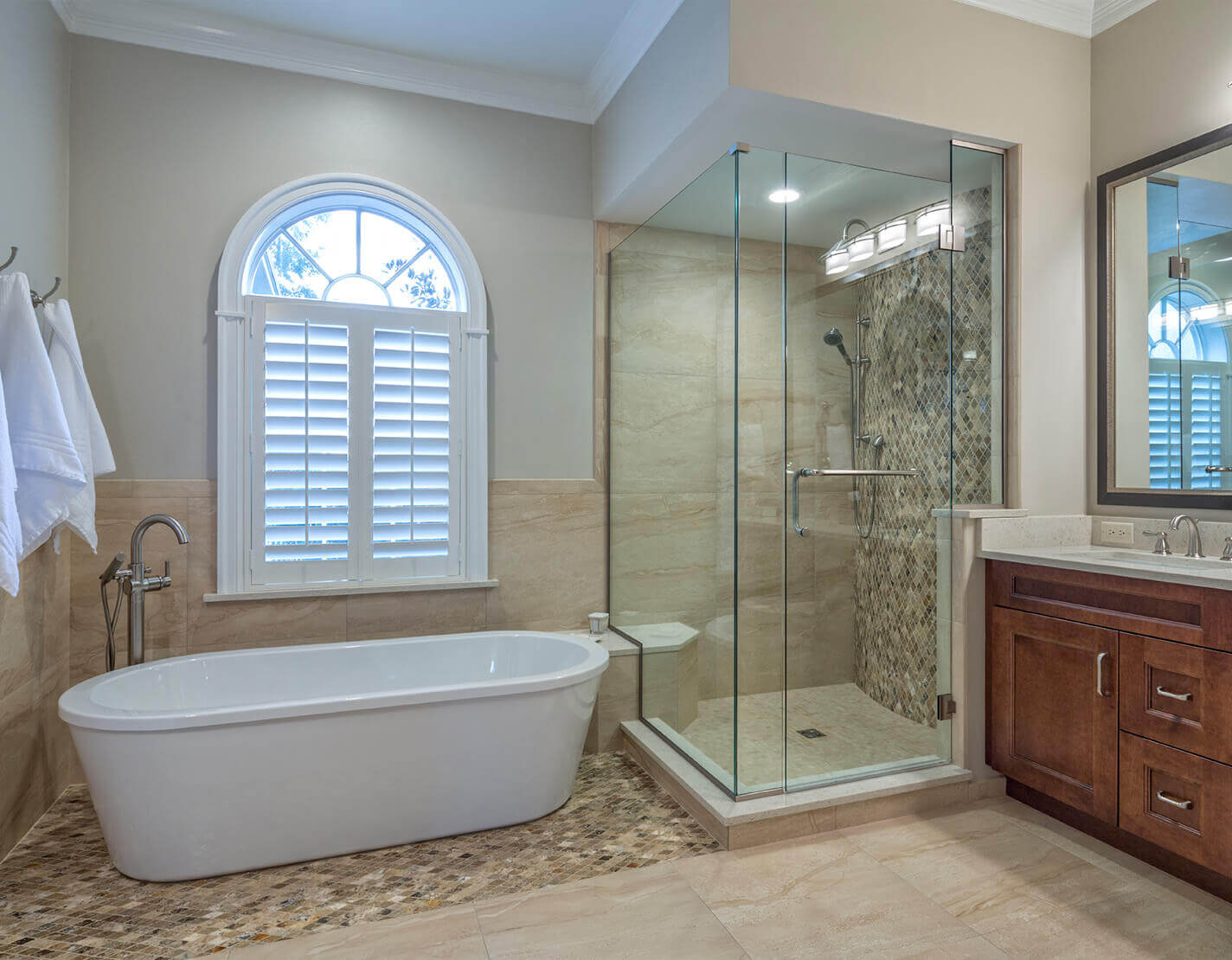 White vinyl window shutters in arched bathroom window