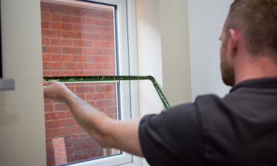 Professional blind fitter measuring a window for blinds